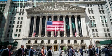 Fachada de la Bolsa de Nueva York con gráficos económicos superpuestos, simbolizando las proyecciones del FMI sobre el crecimiento del PIB de EE. UU.