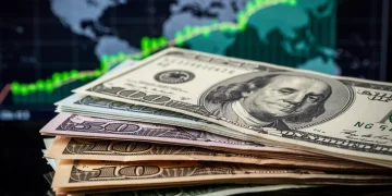 Dólar estadounidense 2026: Análisis de fortaleza y perspectivas Pila de billetes de dólar estadounidense con gráficos financieros de fondo, simbolizando estabilidad económica.